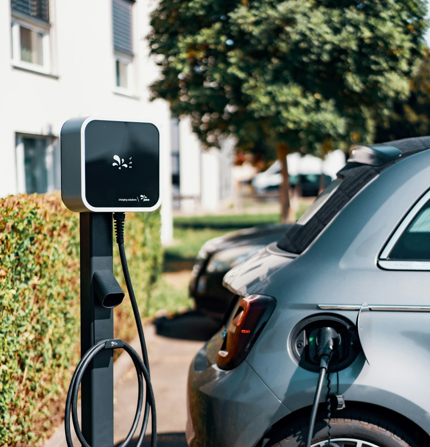 Veículo elétrico ligado a um carregador num estacionamento
